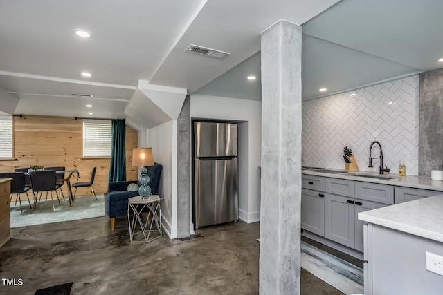 kitchen with stainless steel fridge, gray cabinets, and sink