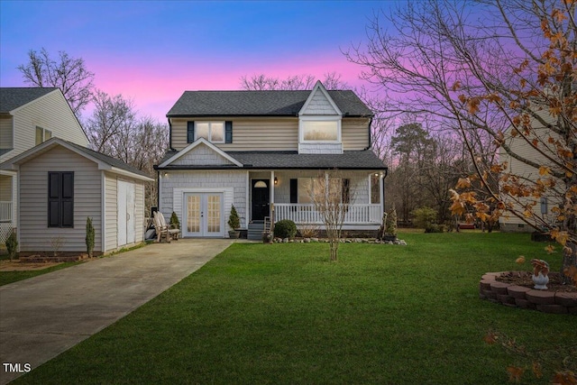 view of front facade with a lawn, a porch, and french doors