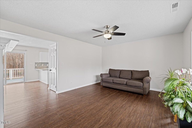 living room with a textured ceiling, dark hardwood / wood-style floors, and ceiling fan