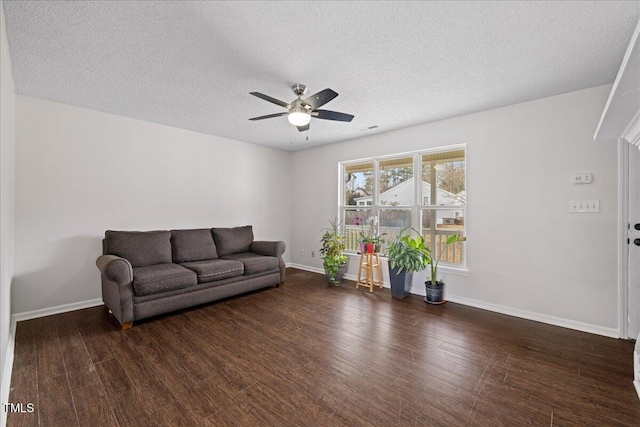 living room with dark hardwood / wood-style floors, ceiling fan, and a textured ceiling