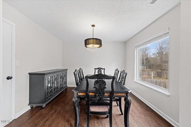 dining room with dark hardwood / wood-style flooring, a chandelier, and a textured ceiling