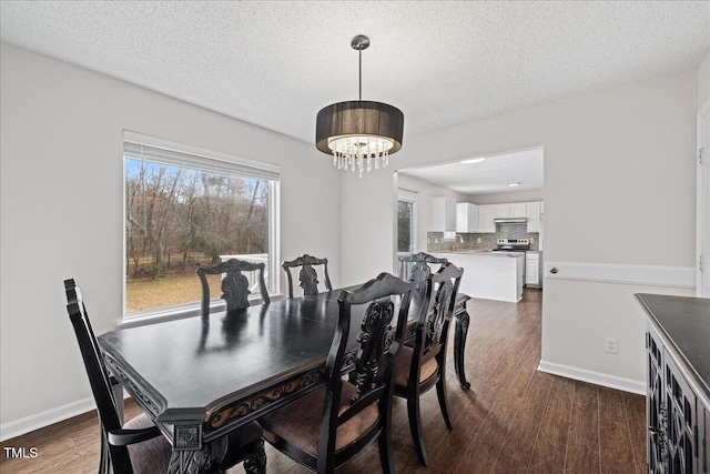 dining space featuring dark hardwood / wood-style floors, a textured ceiling, and an inviting chandelier