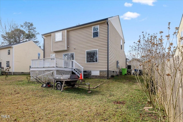 back of house featuring a lawn and a wooden deck