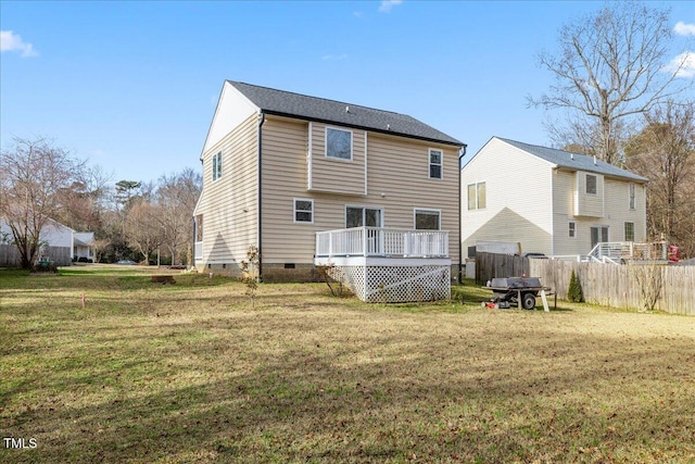 back of property with a deck and a lawn