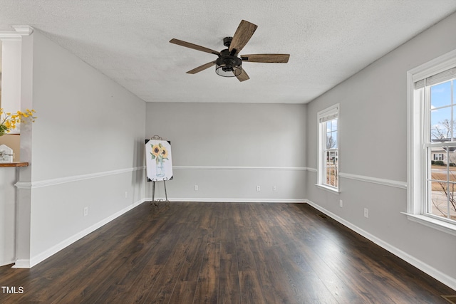 spare room with a textured ceiling, ceiling fan, and dark hardwood / wood-style floors