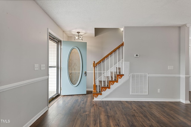 entrance foyer with a wealth of natural light, dark hardwood / wood-style floors, and a textured ceiling