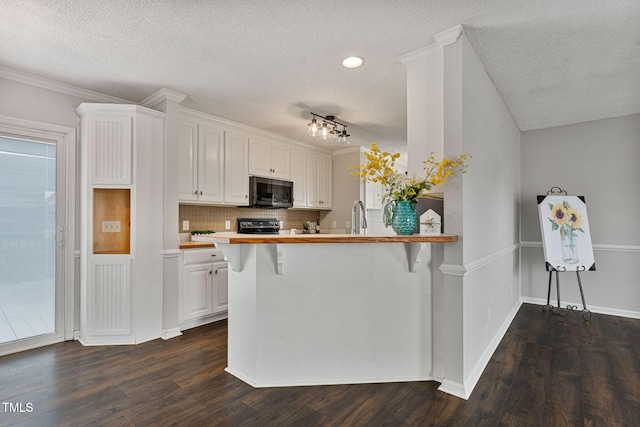 kitchen featuring a breakfast bar, white cabinetry, kitchen peninsula, and dark wood-type flooring