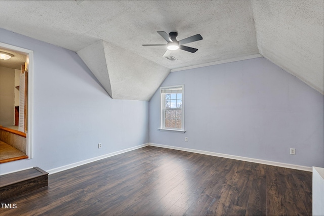 bonus room featuring vaulted ceiling, ceiling fan, dark hardwood / wood-style flooring, and a textured ceiling