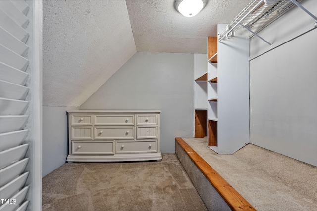 walk in closet featuring light carpet and lofted ceiling