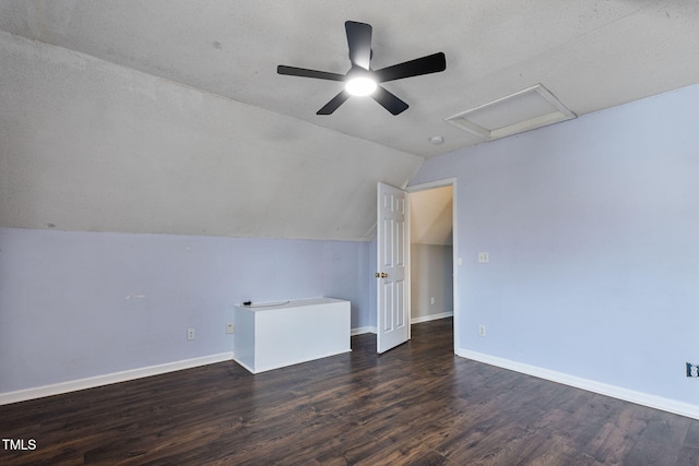 interior space with a textured ceiling, dark hardwood / wood-style flooring, vaulted ceiling, and ceiling fan