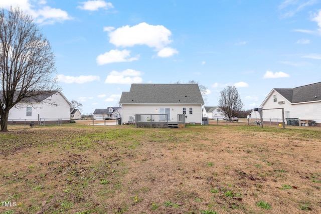 back of property featuring a yard, central AC unit, and a deck