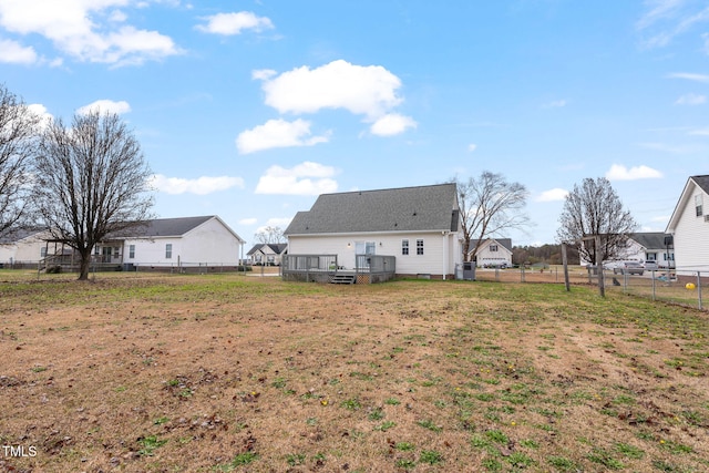 rear view of house with a deck and a yard