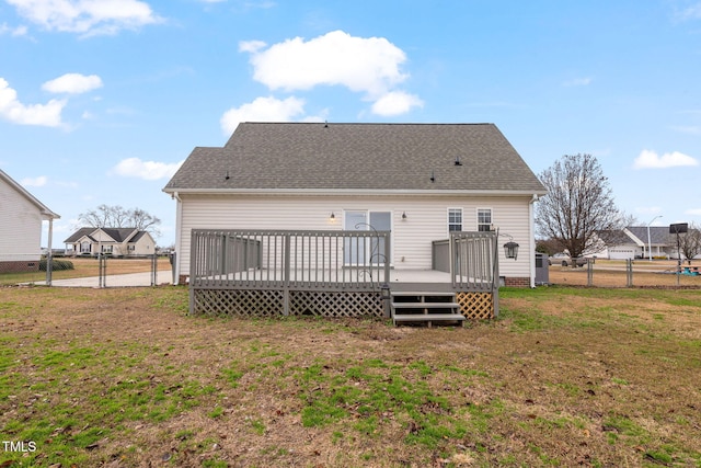 rear view of house featuring a wooden deck and a yard