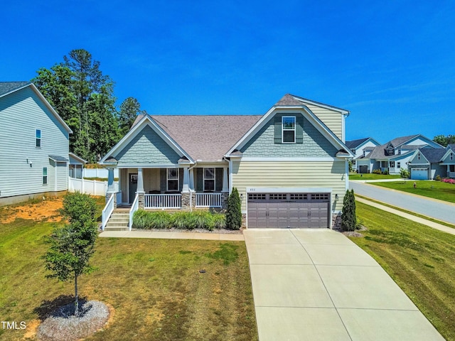 craftsman inspired home featuring a front yard, a porch, and a garage