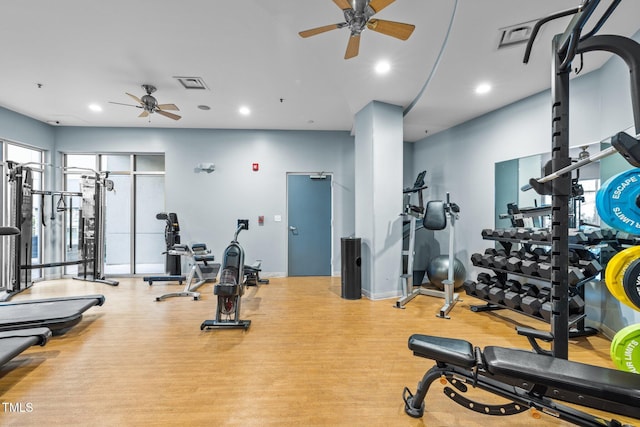 gym with ceiling fan and light hardwood / wood-style floors