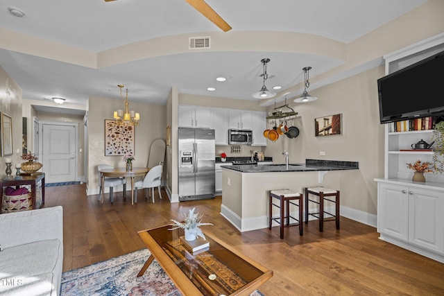 living room featuring a chandelier, sink, and wood-type flooring