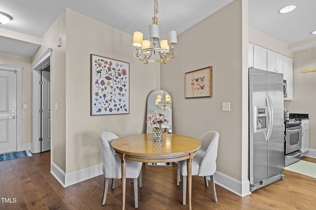 dining area featuring hardwood / wood-style flooring and a notable chandelier