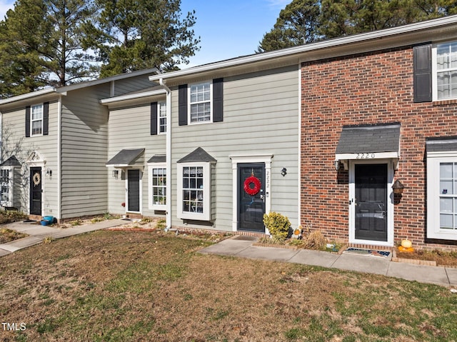 townhome / multi-family property featuring a front yard