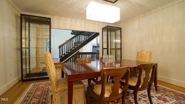 dining area with wood-type flooring and ornamental molding