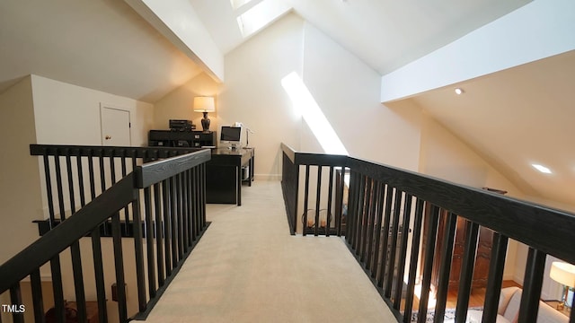 hall with vaulted ceiling with beams and light colored carpet