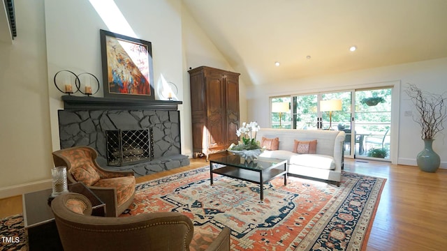 living room with high vaulted ceiling, light hardwood / wood-style flooring, and a stone fireplace