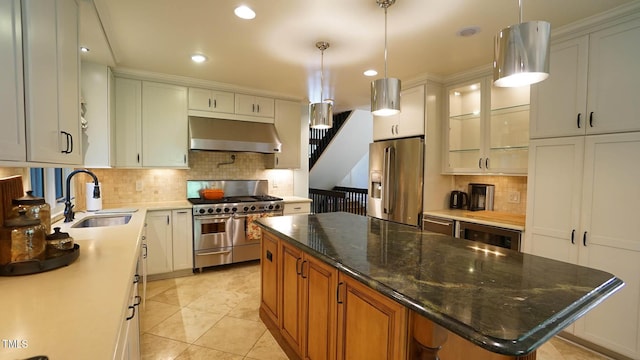 kitchen with stainless steel appliances, sink, white cabinets, a center island, and hanging light fixtures