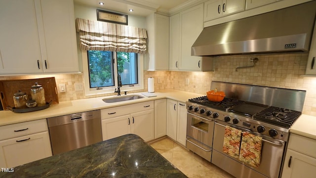 kitchen with sink, light tile patterned flooring, backsplash, white cabinets, and appliances with stainless steel finishes