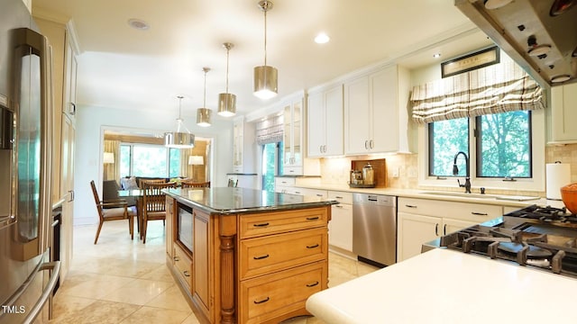 kitchen featuring a center island, white cabinets, decorative light fixtures, and appliances with stainless steel finishes