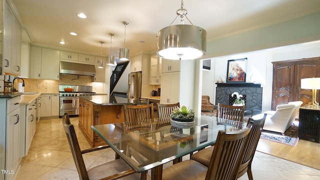 tiled dining room with ornamental molding and sink