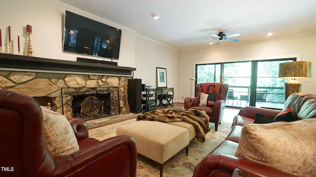 living room featuring a stone fireplace, ceiling fan, and crown molding