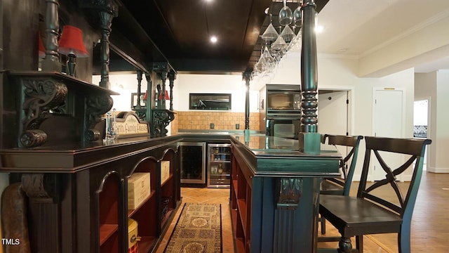 bar featuring ornamental molding, beverage cooler, and tasteful backsplash