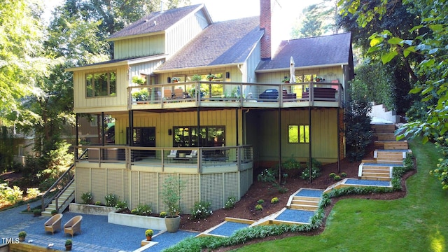 back of property with a patio, a balcony, and a lawn