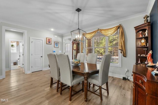 dining space featuring an inviting chandelier, crown molding, and light hardwood / wood-style flooring