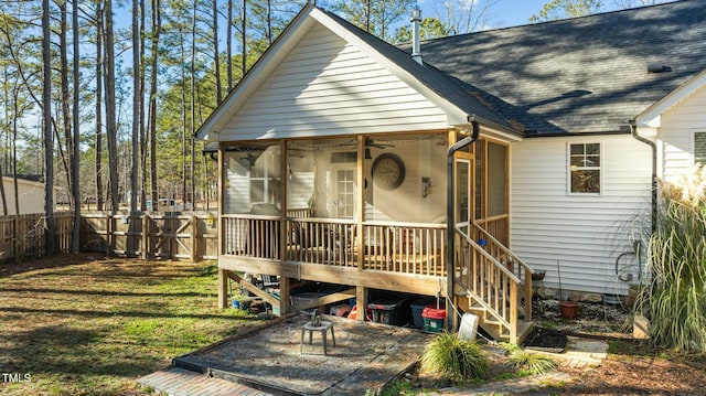 exterior space with a front yard, a wooden deck, and a sunroom