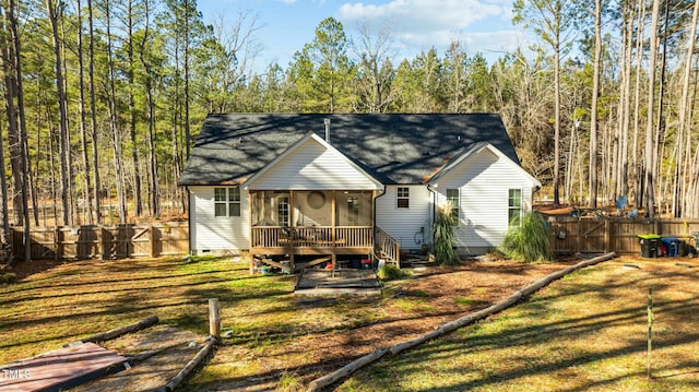 view of front facade featuring a sunroom, a wooden deck, and a front yard