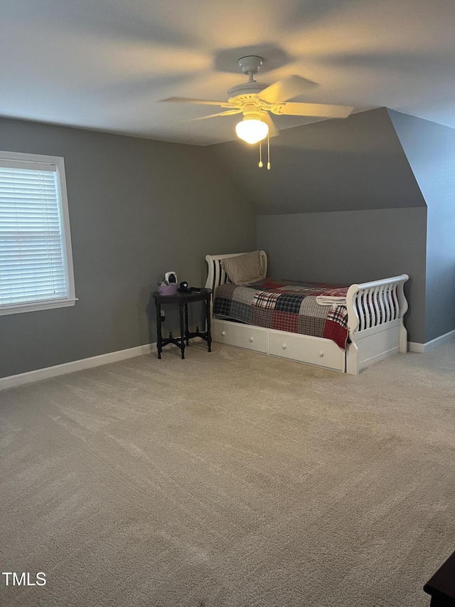 bedroom with ceiling fan, vaulted ceiling, and carpet floors