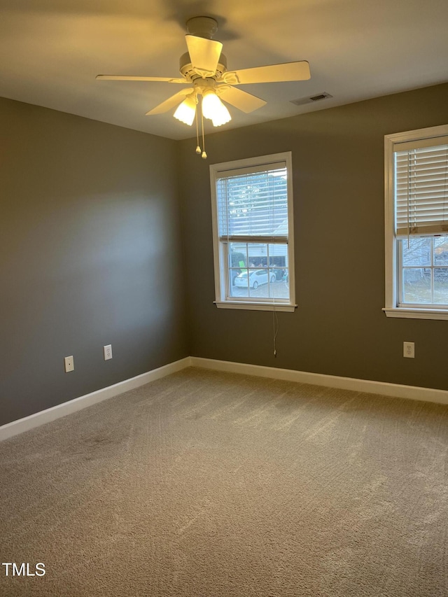 spare room featuring carpet floors, plenty of natural light, and ceiling fan