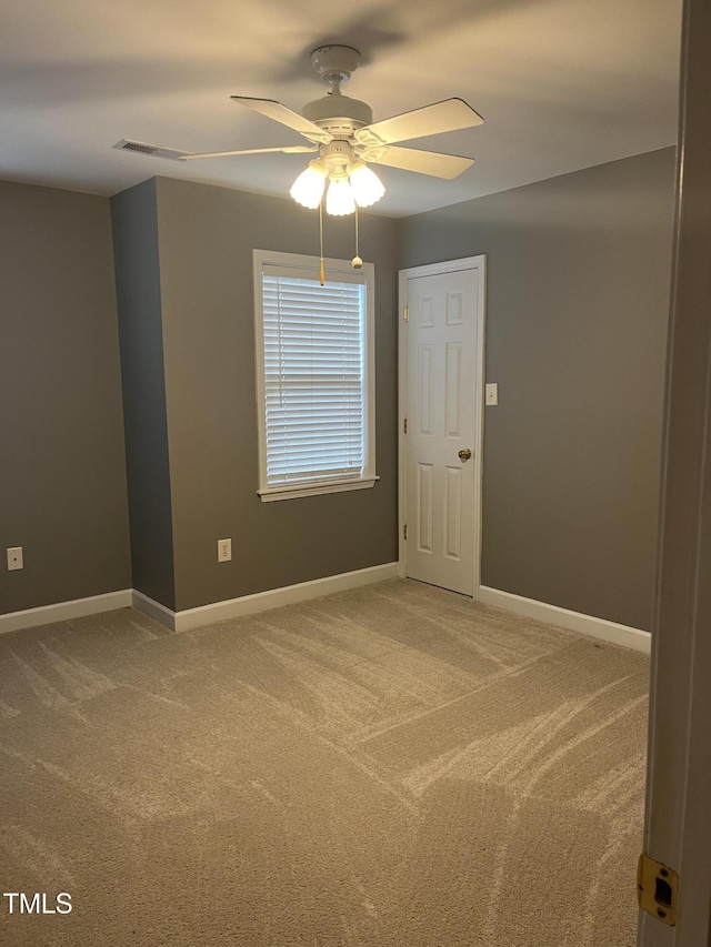 unfurnished room with ceiling fan and carpet flooring