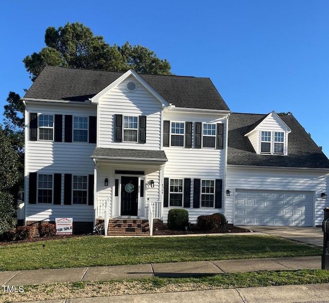 colonial inspired home with a garage and a front yard