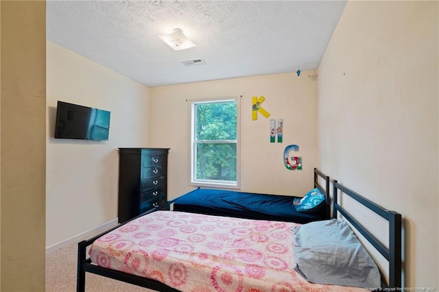 carpeted bedroom featuring a textured ceiling