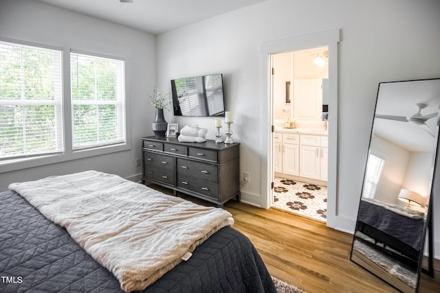 bedroom featuring light hardwood / wood-style floors, ensuite bath, and ceiling fan