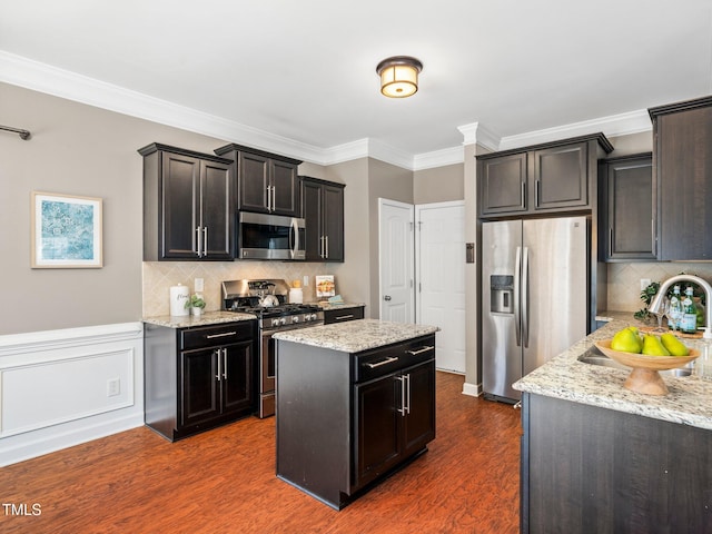 kitchen with a center island, decorative backsplash, dark hardwood / wood-style floors, light stone countertops, and appliances with stainless steel finishes