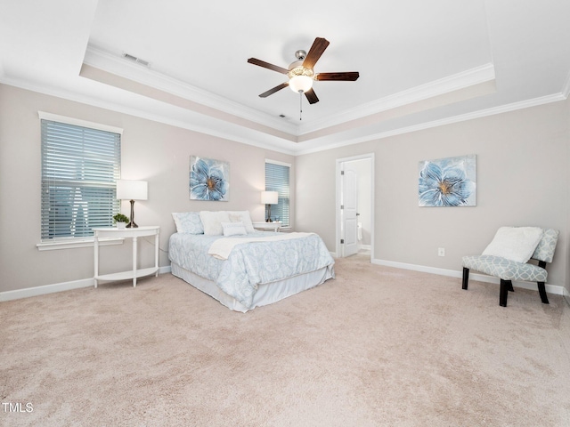 carpeted bedroom with ceiling fan, crown molding, and a tray ceiling