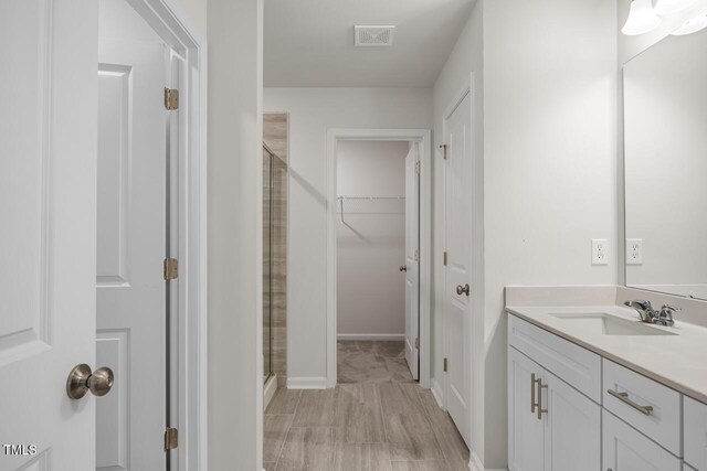 bathroom featuring vanity and a shower with door