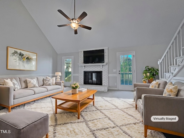 living room featuring a fireplace, light carpet, high vaulted ceiling, and ceiling fan