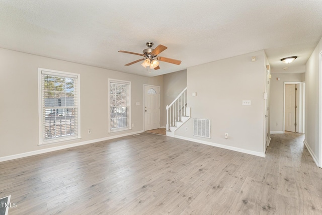 spare room featuring ceiling fan, a textured ceiling, and light wood-type flooring