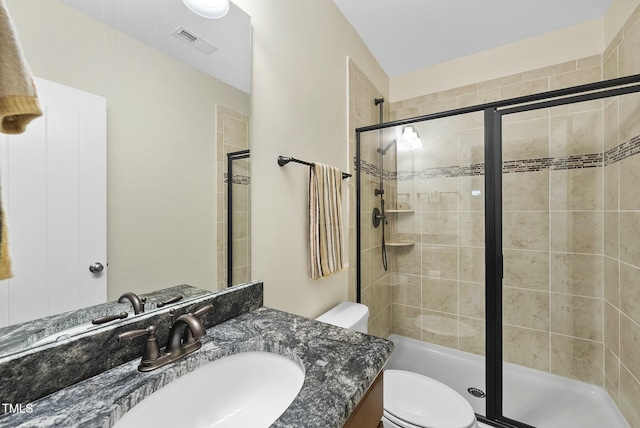 bathroom featuring walk in shower, vanity, and toilet