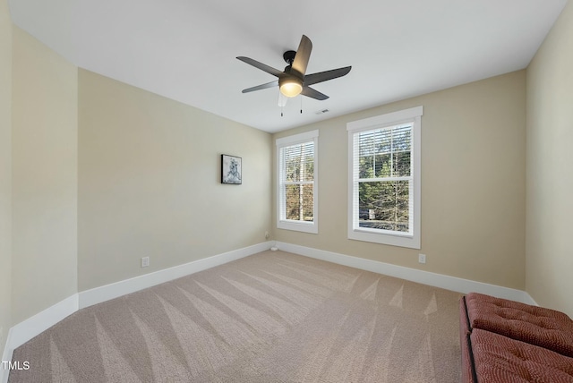 carpeted spare room featuring ceiling fan