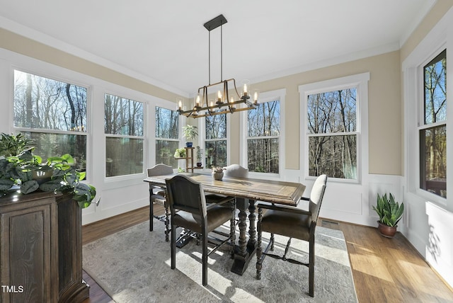 sunroom / solarium featuring plenty of natural light and a notable chandelier