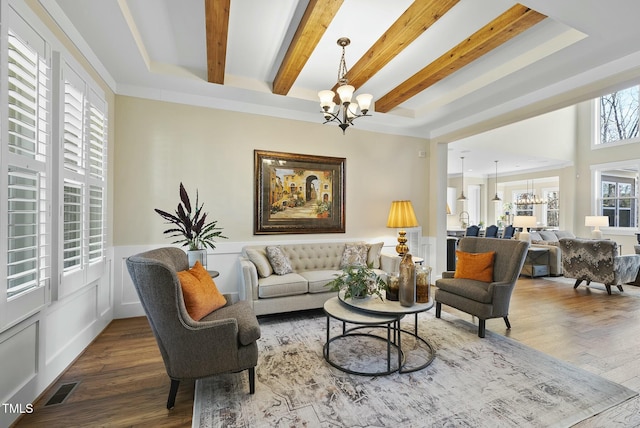 living room with a healthy amount of sunlight, wood-type flooring, sink, and an inviting chandelier